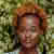 A woman named Olivia Ava with a stylish afro hairstyle, radiating confidence and charm