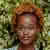 A woman named Olivia Ava with a stylish afro hairstyle, radiating confidence and charm