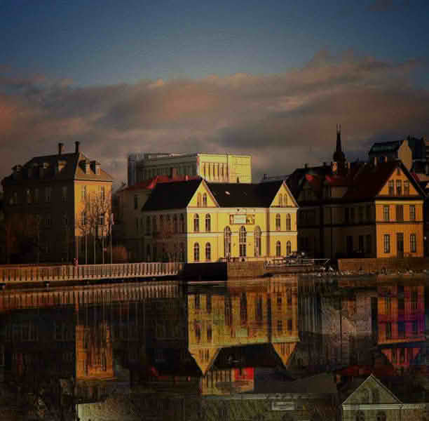 A panoramic view of a large body of water in Reykjavik, reflecting the city's skyline and surrounding landscapes
